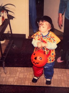 A toddler in a clown costume
